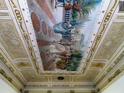 E qui, alzando lo sguardo, restiamo incantati dalla vista del soffitto interamente decorato con teloni dipinti
